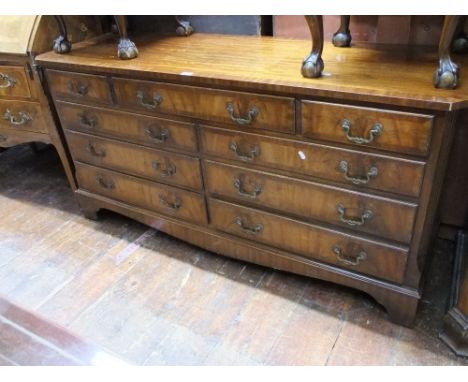 A good quality reproduction Georgian style low chest of nine drawers with pierced brass handles on  bracket supports, 153 cm 
