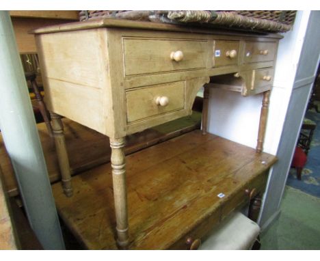 A Victorian stripped and waxed pine kneehole writing desk fitted with five drawers on turned supports