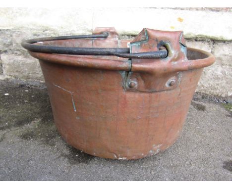 A large vintage circular copper pan with loose iron loop handle together with a circular wooden bowl/vessel with steel straps
