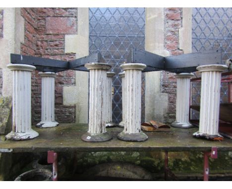 A pair of wooden table bases with four architectural fluted cylindrical column supports and disc shaped stepped platform base