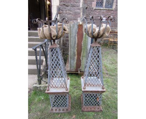 A pair of contemporary light steel garden planters with open strap work and simple scrolled bowls raised on tapered lattice s