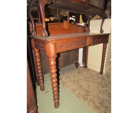 A Victorian oak hall table, the shallow architectural back with shield shaped central plaque over two frieze drawers with car