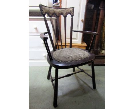 An Arts & Crafts elbow chair with stick back upholstered cresting rail raised on simple turned supports and stretchers