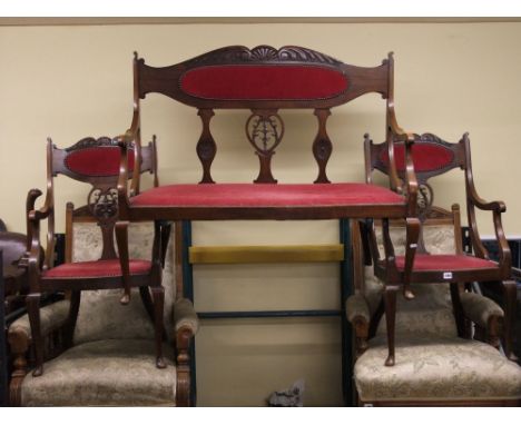 An Edwardian mahogany three piece parlour room or salon suite comprising a two seat sofa and two matching arm chairs, each wi