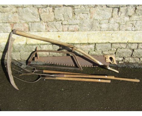 A vintage agricultural scythe with long ashwood handle together with two pitch forks, a saw and slasher with further ashwood 