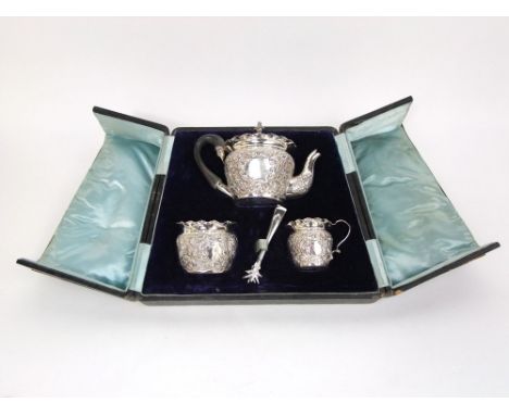 A late 19th century cased three piece silver bachelor tea service comprising tea pot, milk jug and sucrier, all heavily chase