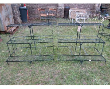 A pair of contemporary green painted light steel three tier stepped plant stands with wire treads