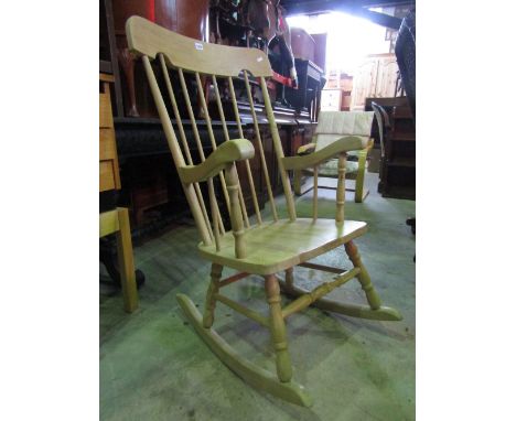 A light beechwood stick back rocking chair with shaped arms, turned supports and stretchers 