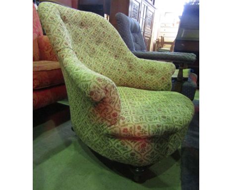 A Victorian drawing room chair with floral patterned upholstery, button back, shaped outline, swept and rolled arms raised on