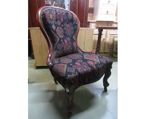 A Victorian nursing chair with stylised kelim style serpentine upholstered seat and button back within a walnut frame raised 