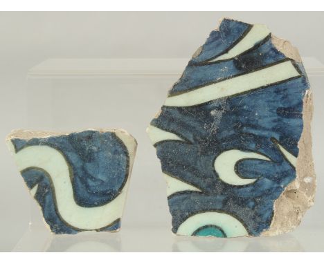 TWO 16TH CENTURY OTTOMAN DAMASCUS CALLIGRAPHIC TILE FRAGMENTS, largest 14.5cm at widest point, (2).