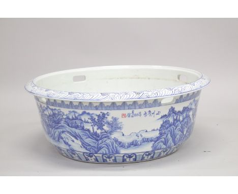 A VERY LARGE CHINESE BLUE AND WHITE PORCELAIN WATER BASIN, the exterior decorated with landscape scenes, 81cm diameter.