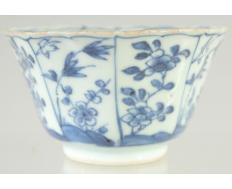 A CHINESE KANGXI BLUE AND WHITE PORCELAIN TEA BOWL, painted with panels of flora, interior with central panel of female figur