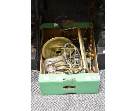 A selection of vintage brass trivets, a candlestick and similar flat ware.