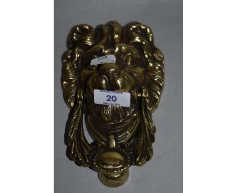 A 19th/20th Century cast metal door knocker in the form of a lion's head, measuring 18cm