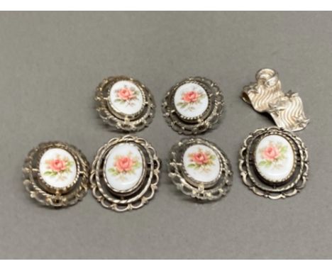 Six continental silver and ceramic brooches and a white metal pendant