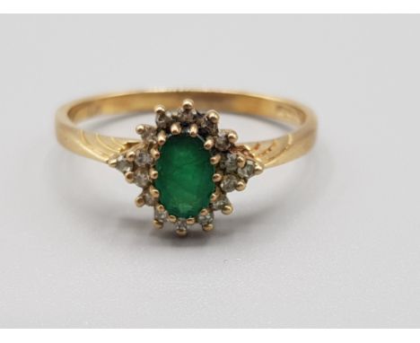 Ladies 9ct yellow gold green stone + diamond cluster ring, featuring an oval green stone set in the centre surrounded by 16 r