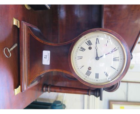 An Edwardian crossbanded mahogany waisted mantel clock with white dial and brass ogee feet, the twin train balance wheel move