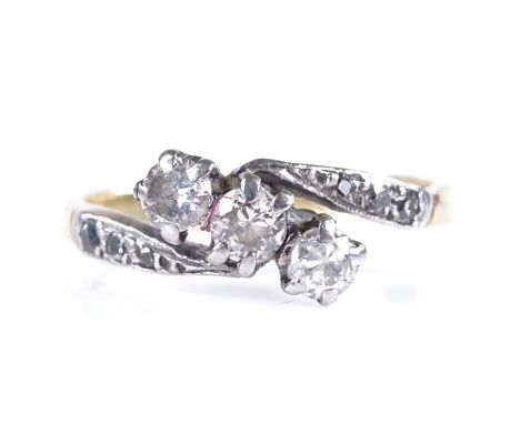 An unmarked gold 3-stone diamond crossover ring, with diamond set shoulders, setting height 7.5mm, size K, 2.3g 