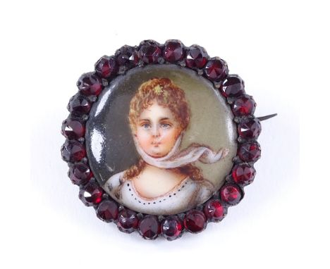 An Antique miniature painted portrait ceramic and faceted garnet brooch, in unmarked garnet gold setting, diameter 28mm, 5.3g