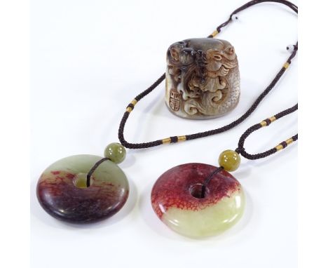 2 Chinese coloured jade disc pendants on cords, diameter 5cm, and a carved horn ornament (3) 