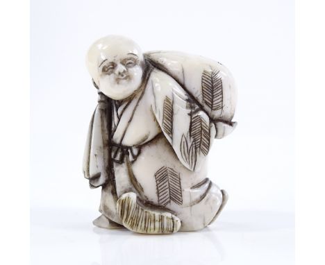 A Japanese Meiji period ivory netsuke, in the form of a man carrying a sack, height 4cm 