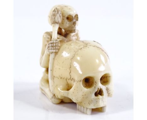 A Japanese Meiji period carved ivory skeleton and skull design netsuke, signed, height 4cm