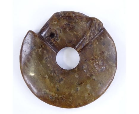 A Chinese carved and pierced jade disc, 6.5cm across 