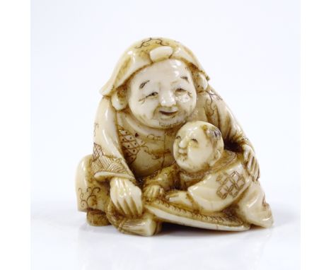 A Japanese carved ivory netsuke, in the form of a figure with a boy, signed, height 3cm 