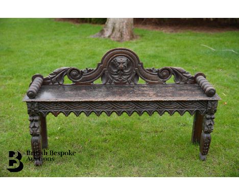 A Victorian carved oak hall bench, the low back with arched back with lion mask, with bobbin turned bolsters at each end, app
