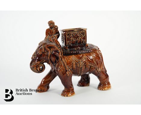 A brown glazed tobacco jar, modelled as an elephant with his mahout, approx 20 x 18 cms.&nbsp;