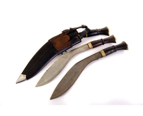 A Kukri knife in leather scabbard, missing two smaller knives, together with two other Kukri knives (3)