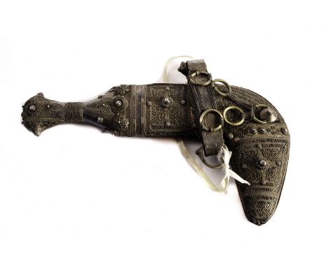 A vintage Middle Eastern jambiya dagger, in white metal with filigree and prunt designs and leather panel to reverse