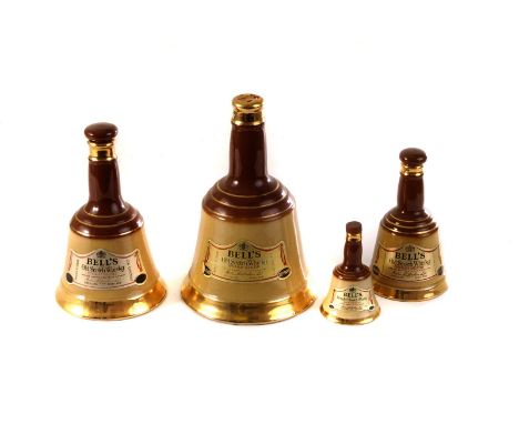 A graduated set of four vintage bell shaped Bell's whisky decanters, all with contents, one with broken cork top, some evapor