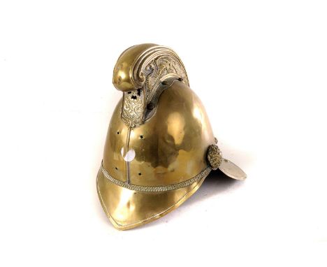 A vintage brass fire helmet, missing badge and chin strap, with decoration embossed dragons to side of the high comb