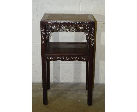An early-20th century Chinese hardwood urn stand, the two tiers with square legs carved at the foot, inlaid overall with moth
