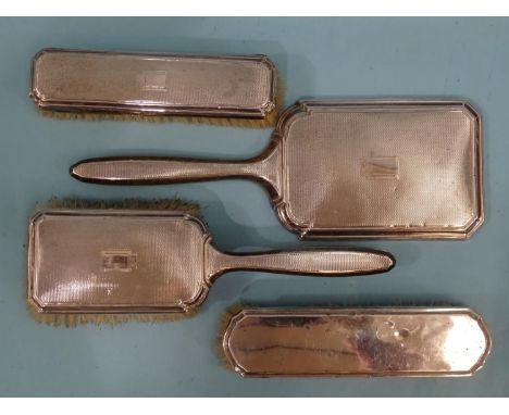 A three-piece engine-turned silver-backed dressing table set, comprising: hand mirror, hair brush and clothes brush, Birmingh