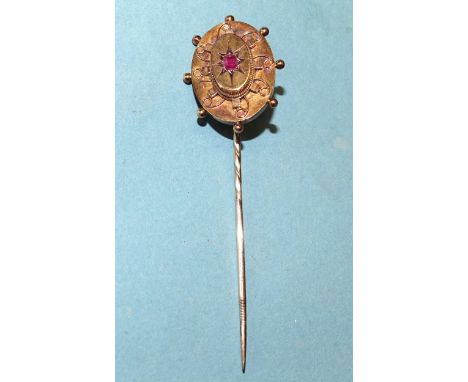 A Victorian stickpin&nbsp; set ruby in oval plaque with cannetille decoration, 22 x 20mm, 3.9g.