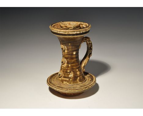 An undated archaistic olive-glazed ceramic vessel with waisted tubular body, flange to the bottom and dished flange above wit