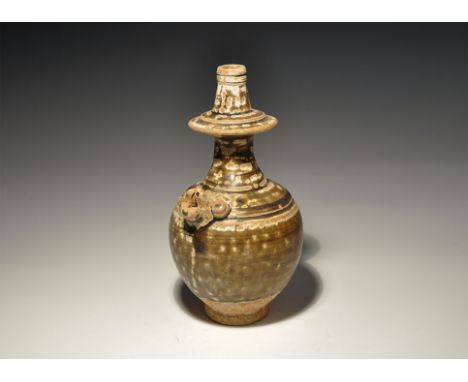 An undated archaistic black-glazed ceramic jar with piriform body, tall tapering neck with median flange, animal-head spout t