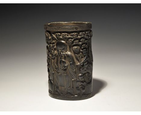 20th century AD. A tall composition pot with geometric rim, high-relief design of a facing robed figure holding a fruit and s