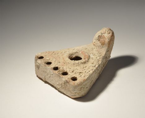6th-10th century AD. A terracotta triangular hollow-formed lamp with rimmed filler spout, five nozzles to the forward edge, b