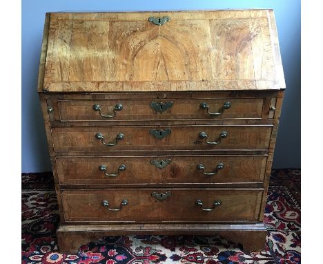 An 18th century George II/III walnut bureauThe feather banded top above the feather banded fall with brass escutcheon enclosi