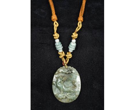 A Chinese carved jade pendantCarved with a mythical beast beneath a bat, the reverse also carved to the top with a bat, mount