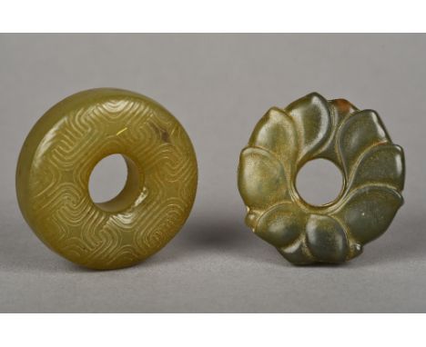 Two Chinese carved jade roundelsEach centrally pierced.  The largest 5.25 cm diameter.  (2)   CONDITION REPORTS:  Generally g