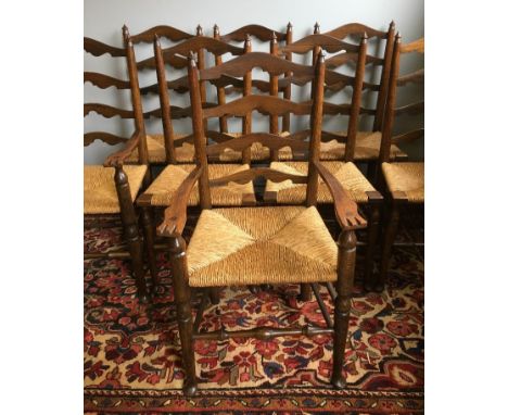 A set of eight Arts and Crafts ladder back dining chairs, including two with armsEach with shaped ladder backs over the rush 