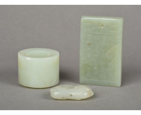 A Chinese carved celadon jade archer's ringTogether with a carved celadon jade pendant tablet, worked with calligraphic text;