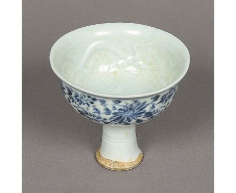 A Chinese porcelain stem cupThe interior relief decorated with dragons, the exterior with lotus strapwork.  11 cm high.    CO