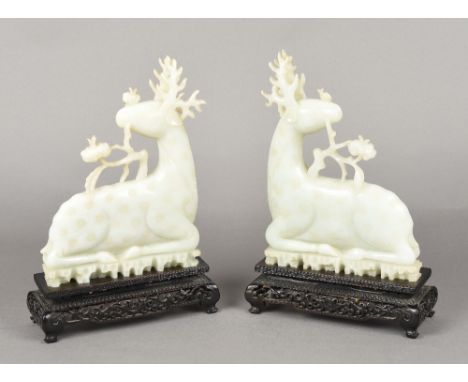 A pair of Chinese carved celadon jade stagsBoth worked recumbent, standing on carved and pierced wooden bases.  30 cm high ov