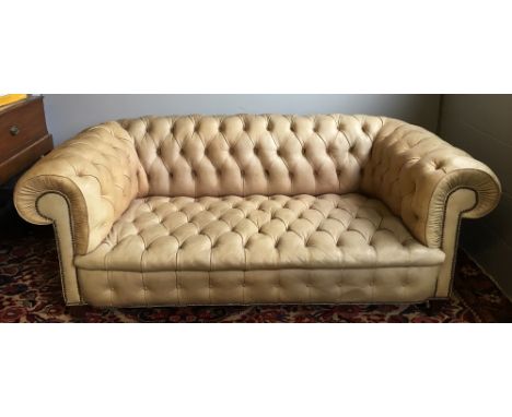 A vintage leather covered buttoned Chesterfield setteeOf typical scrolling form, standing on square section tapering legs wit